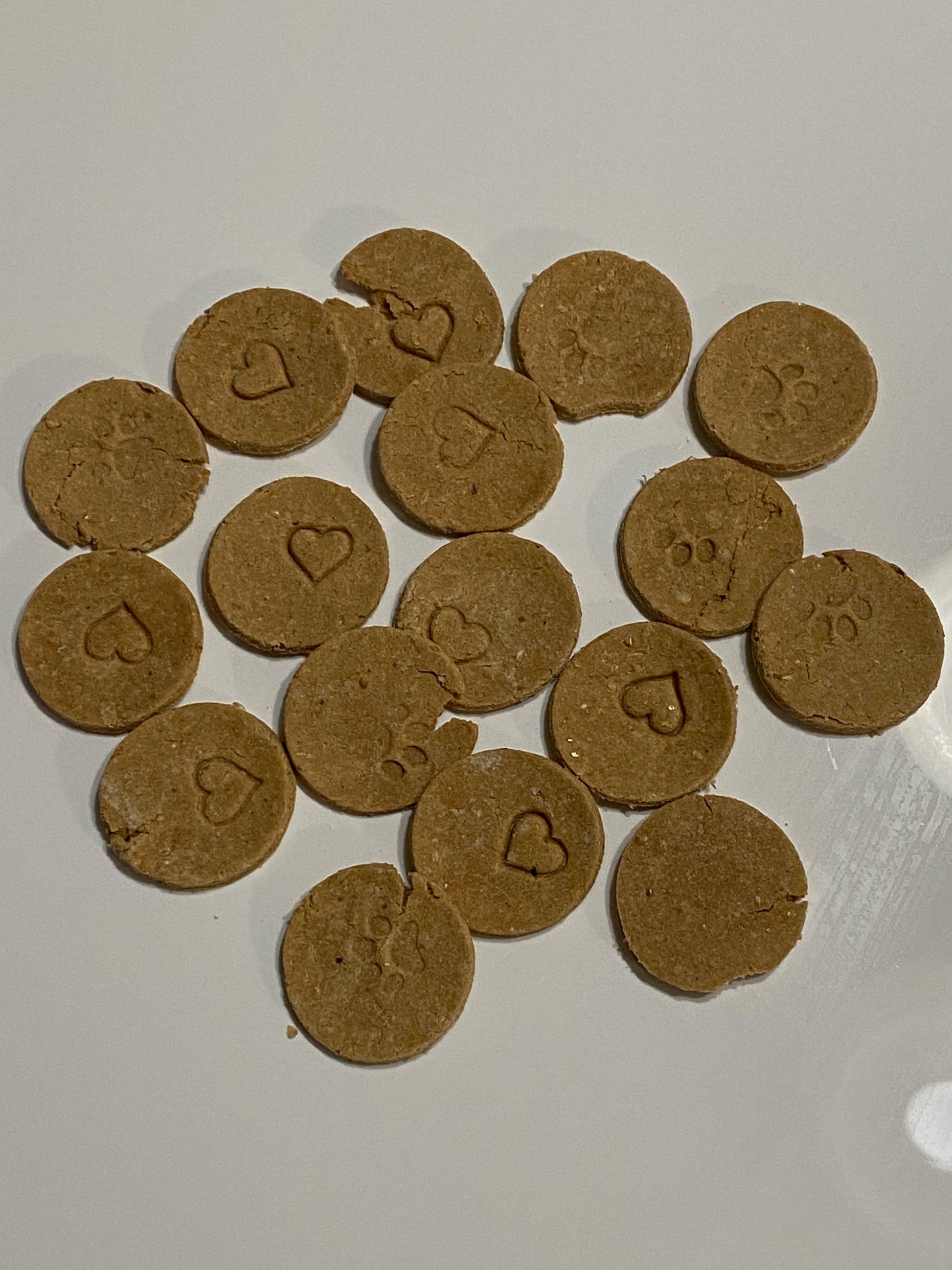 1.5 inch round dog treats, color brown stamped with hearts and paw prints